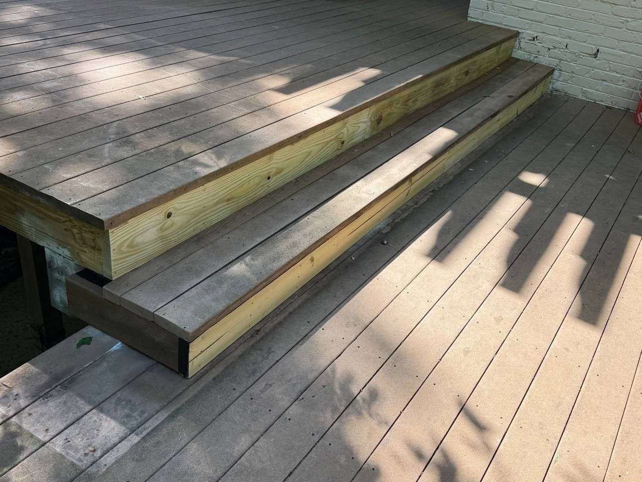 Newly rebuilt pressure-treated deck stairs with new stringers and framing, replacing rotted structural wood in Chattanooga